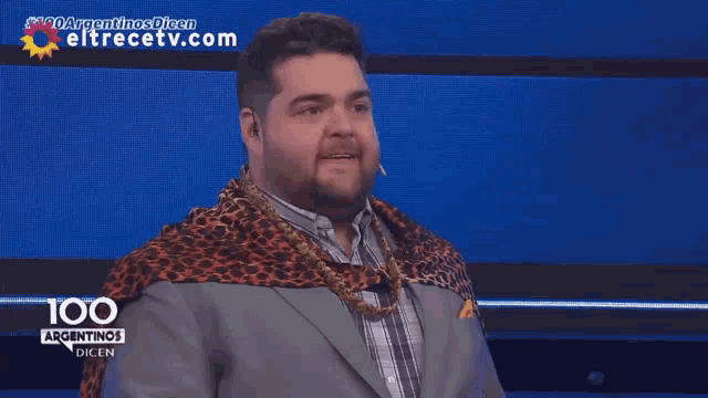 a man with a leopard print scarf around his neck is on a tv show called 100 argentinos dicen