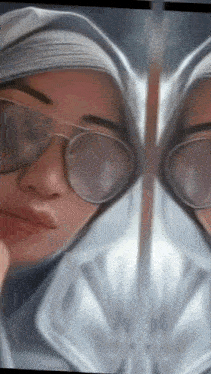 a woman wearing sunglasses and a hijab looks at her reflection in the mirror