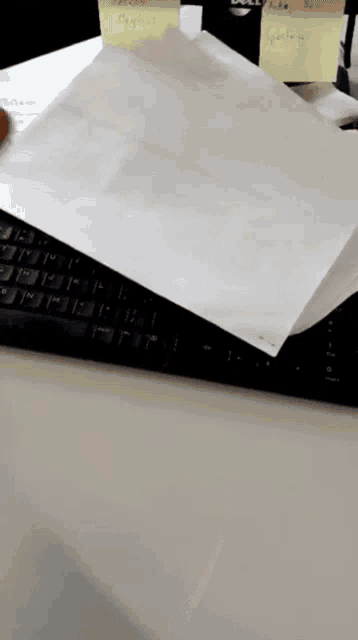 a piece of paper is laying on top of a keyboard with sticky notes on it including one that says " people "
