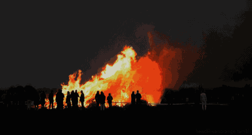 a group of people standing in front of a large fire with the words headfirststrange.tumblr below them
