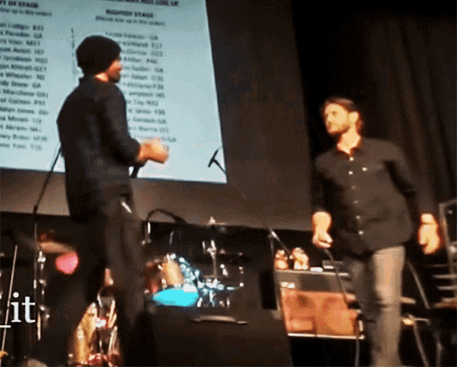 two men standing on a stage in front of a screen that says ' line up '
