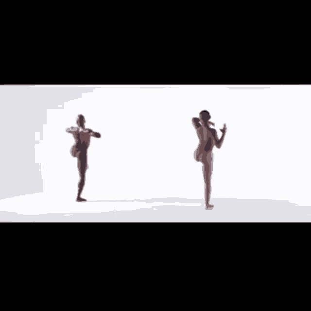 a naked man is dancing in front of a white background and a woman 's hands are reaching out towards him .
