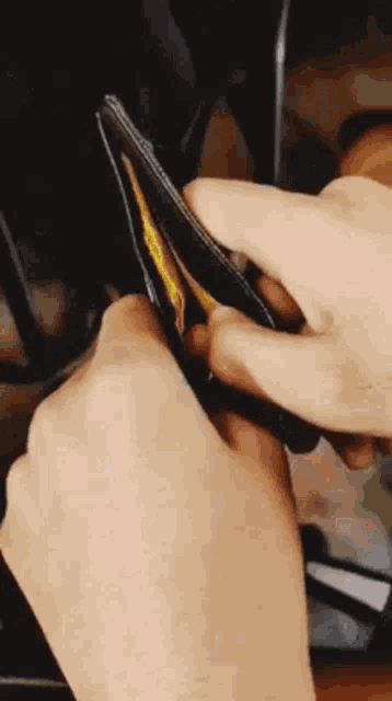 a person is opening a wallet with a credit card in it
