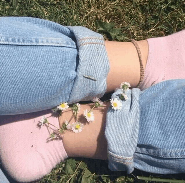 a person wearing blue jeans and pink socks with daisies on their feet