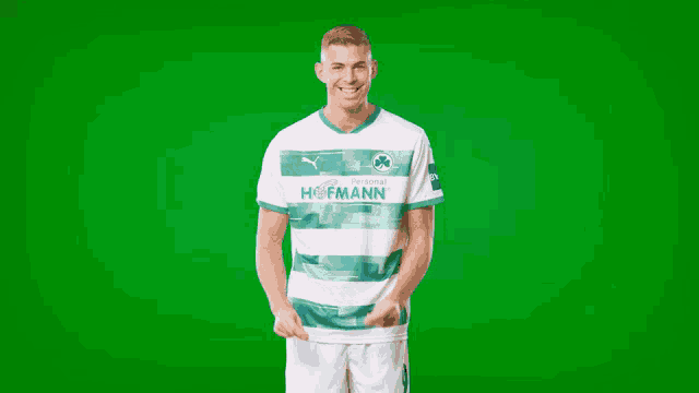 a man is wearing a green and white hofmann jersey