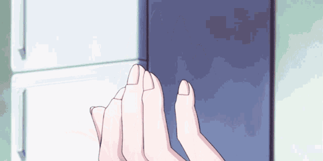a person 's hands are reaching out towards a refrigerator door .