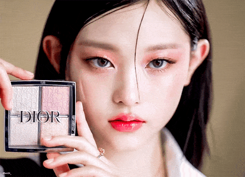 a woman is holding a dior product in her hand