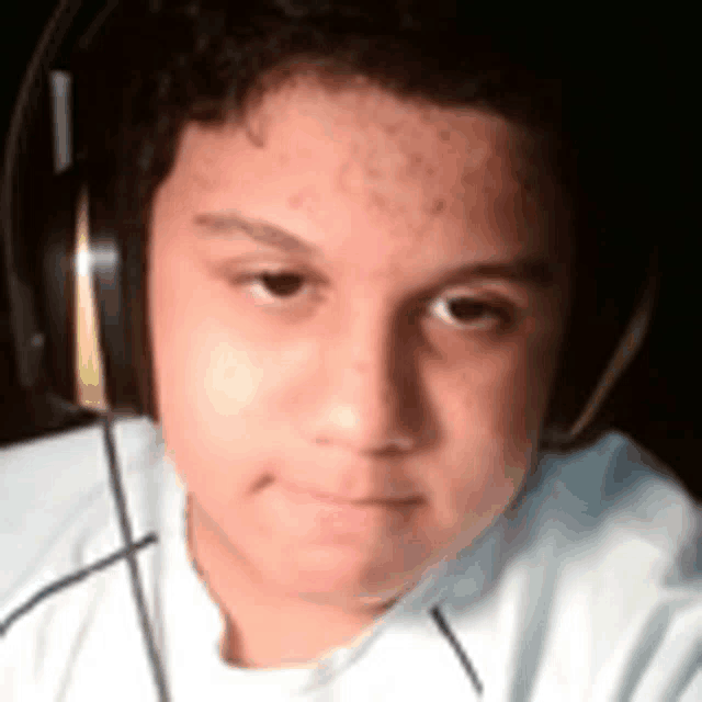 a young boy wearing headphones looks at the camera with a serious look on his face