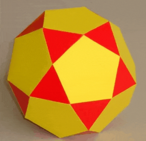 a yellow and red ball with a square in the middle is on a table .
