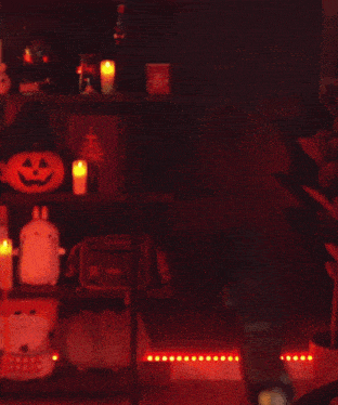 a man in a red vest is dancing in a dark room with red lights