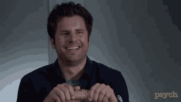 a man in a black shirt is smiling and holding something in his hands in front of a psych logo .