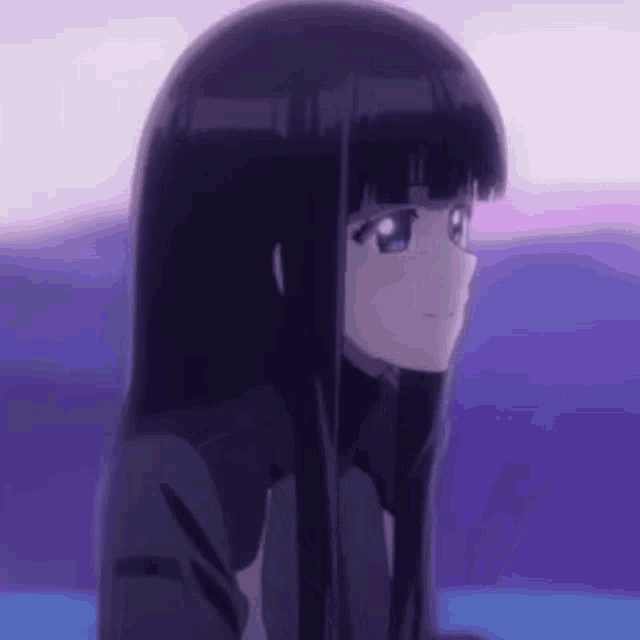 a close up of a girl with long black hair and blue eyes looking at something .