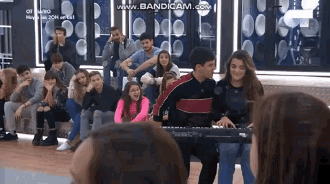 a man is playing a keyboard in front of a crowd .