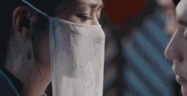 a woman wearing a face mask looks at another woman