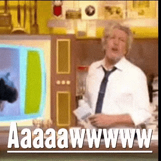 a man in a white shirt and tie is standing in front of a screen that says aaaaawwwwww