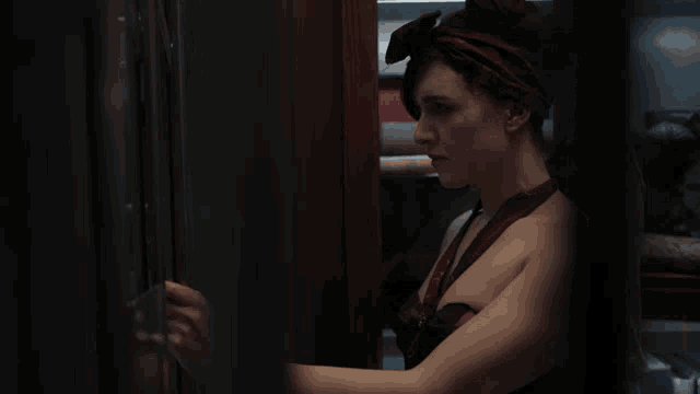 a woman with a scarf around her head is standing in a closet