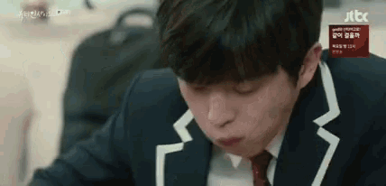 a man in a suit and tie is sitting at a table eating something .