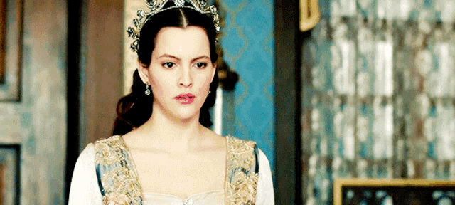 a woman wearing a tiara and a white and gold dress