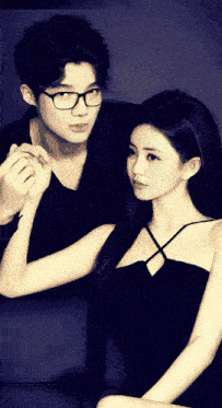a man and a woman are posing for a picture and the woman is wearing glasses
