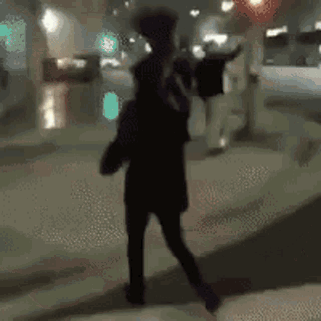 a blurry picture of a person walking on a street at night .