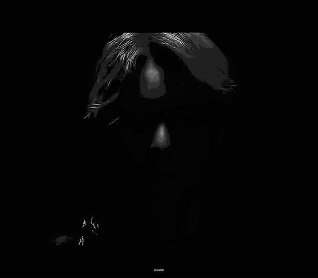 a black and white photo of a man 's face in the dark