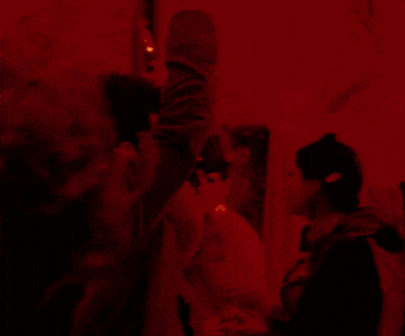 a blurred image of a person in a dark room with a red light behind them