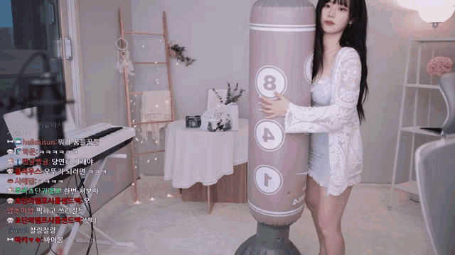 a woman in a white dress holds a punching bag with the number 8 on it