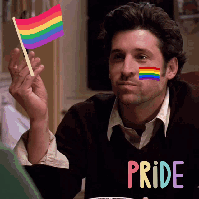 a man with a rainbow flag painted on his face is wearing a pride sweater