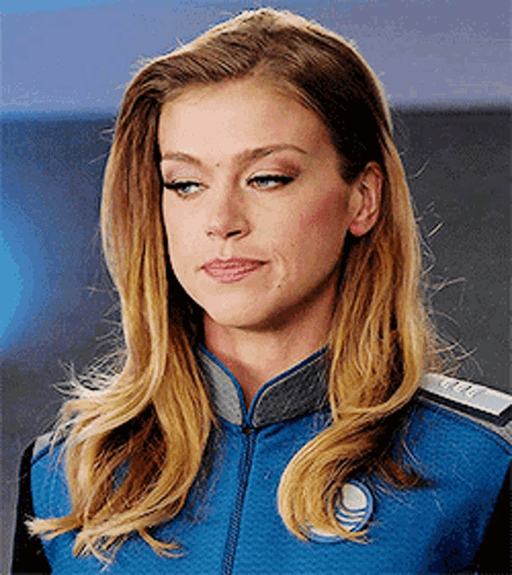 a woman is wearing a blue jacket with a badge that says ' u.s. navy ' on it