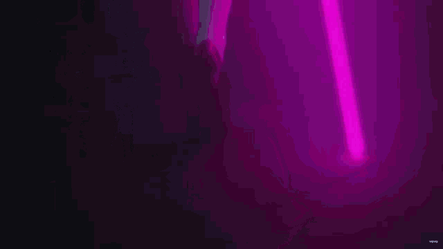 a purple light beam is coming out of a purple object .