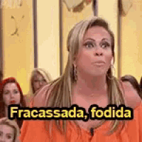 a woman is sitting in front of a crowd with a caption that says fracassada , fodida .
