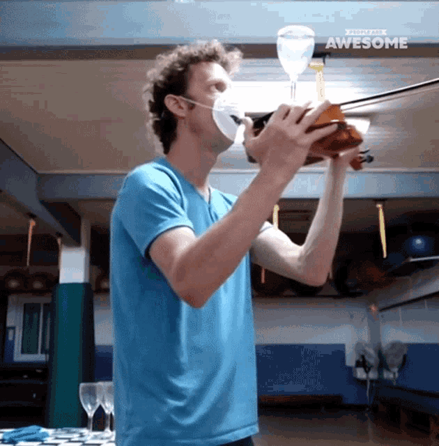 a man wearing a mask is playing a violin and the words awesome are on the ceiling