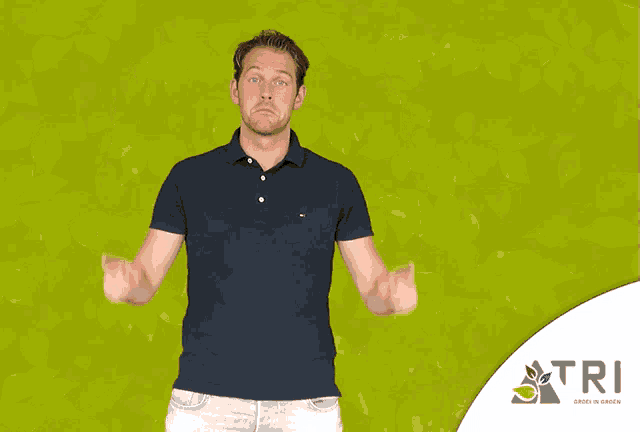 a man in a black shirt is pointing up in front of a green background with the word tri on it