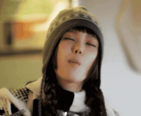 a woman wearing a hooded hat is eating something