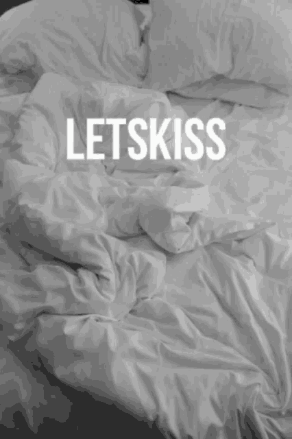 a bed with white sheets and pillows with the words letsfuck written on the top