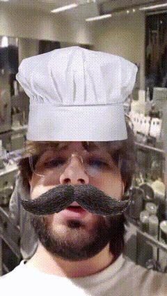 a man with a beard and mustache wears a chef 's hat