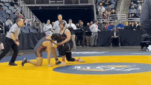 two wrestlers are wrestling on a mat that has the word usc on it