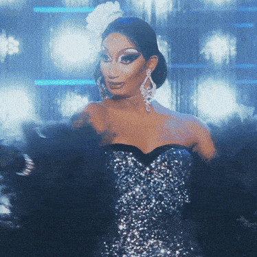 a drag queen wearing a blue and silver dress