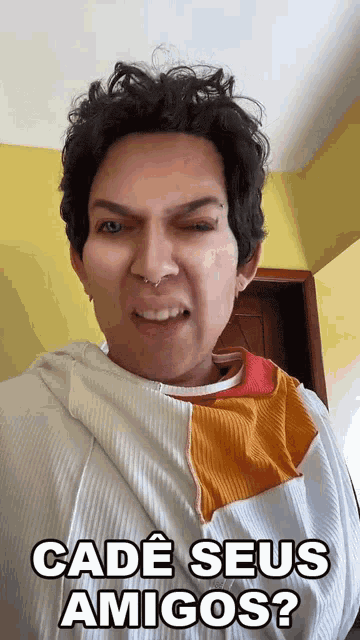 a man with a piercing in his nose is making a funny face and says " cadé seus amigos "