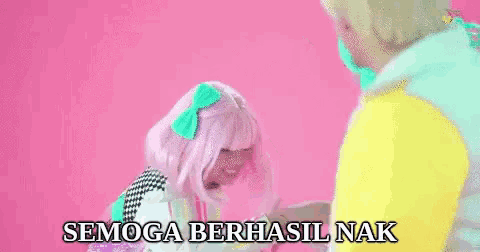 a man and a woman are making a heart shape with their hands . the woman is wearing a pink wig .