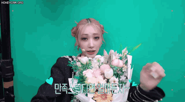 a woman holding a bouquet of flowers in front of a green screen