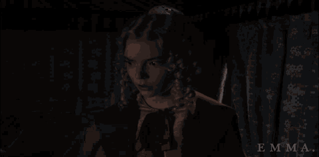 a woman in a red jacket with the word emma on the bottom right