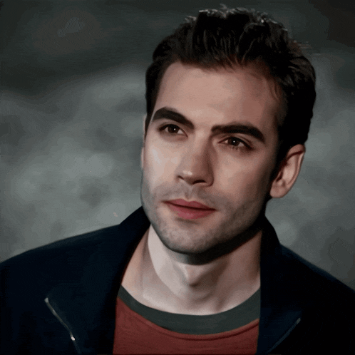 a close up of a man 's face with a black jacket on