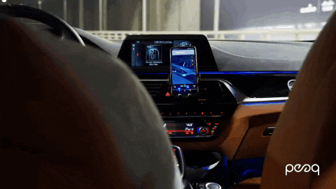 a person is sitting in a car with a phone on the dashboard and the word peoq is on the bottom