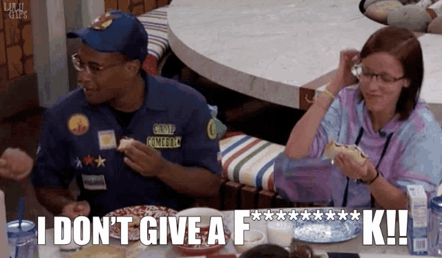 a group of people are sitting at a table and one of them says i don t give a f *** k