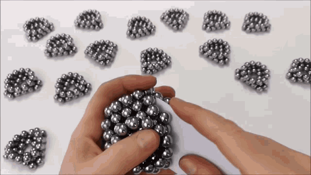 a person is holding a bunch of metal beads in their hands