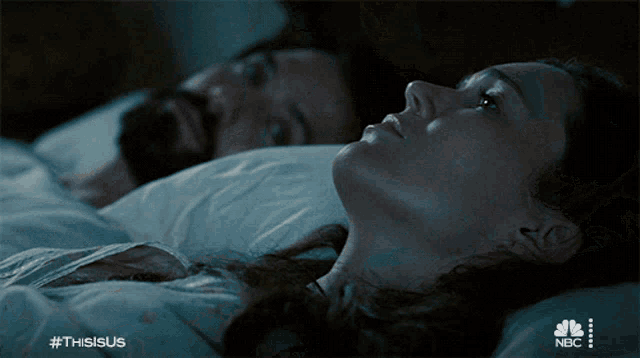 a man and a woman are laying in bed with the hashtag thisisus