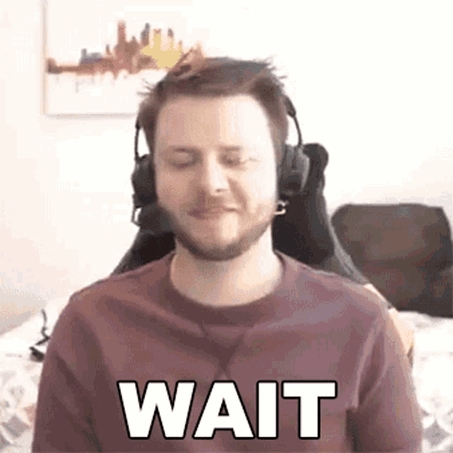 a man wearing headphones is sitting on a bed and making a funny face .