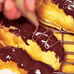 a close up of a person spreading chocolate on a pastry .
