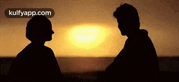 a man and a woman are looking at each other in front of the sun .